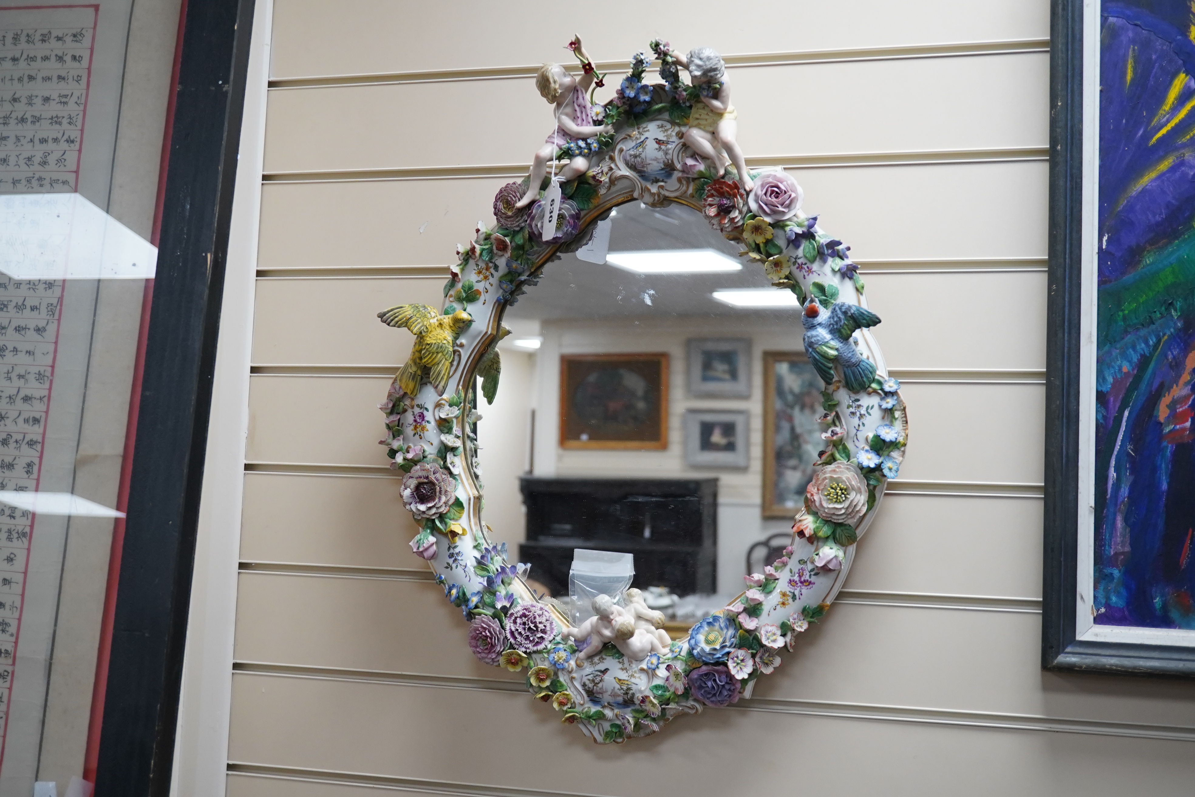 A Meissen style porcelain floral encrusted and figural mirror, 64cm high. Condition - fair, minor losses